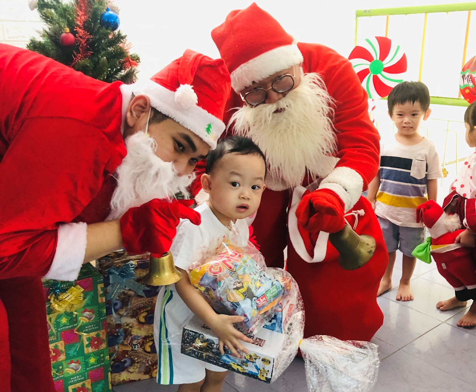 Ông già Noel vui vẻ phát quà cho trẻ em trước Giáng sinh