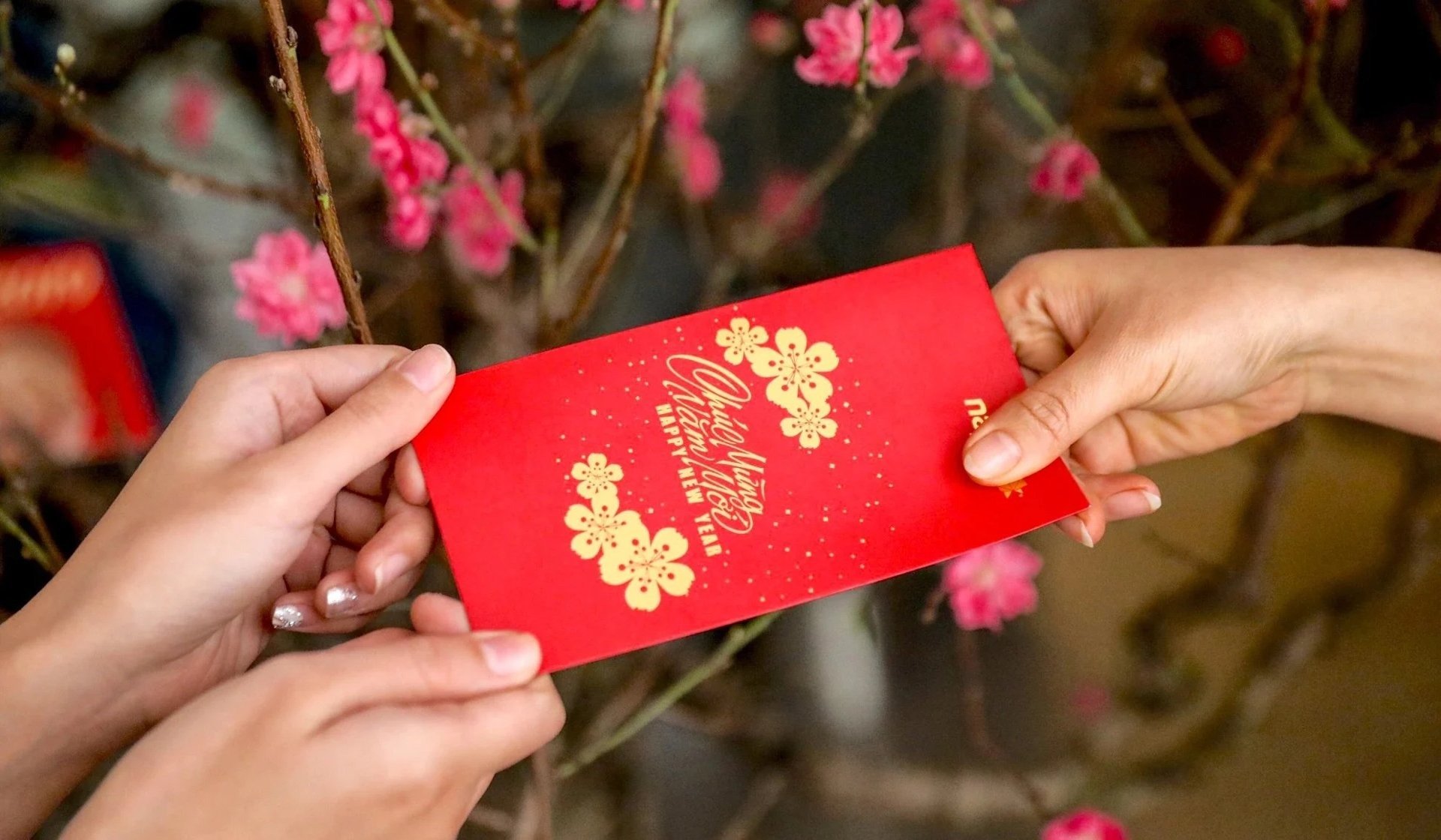 Tặng phong bao lì xì cho người xông nhà là một cách trao đổi may mắn tích cực